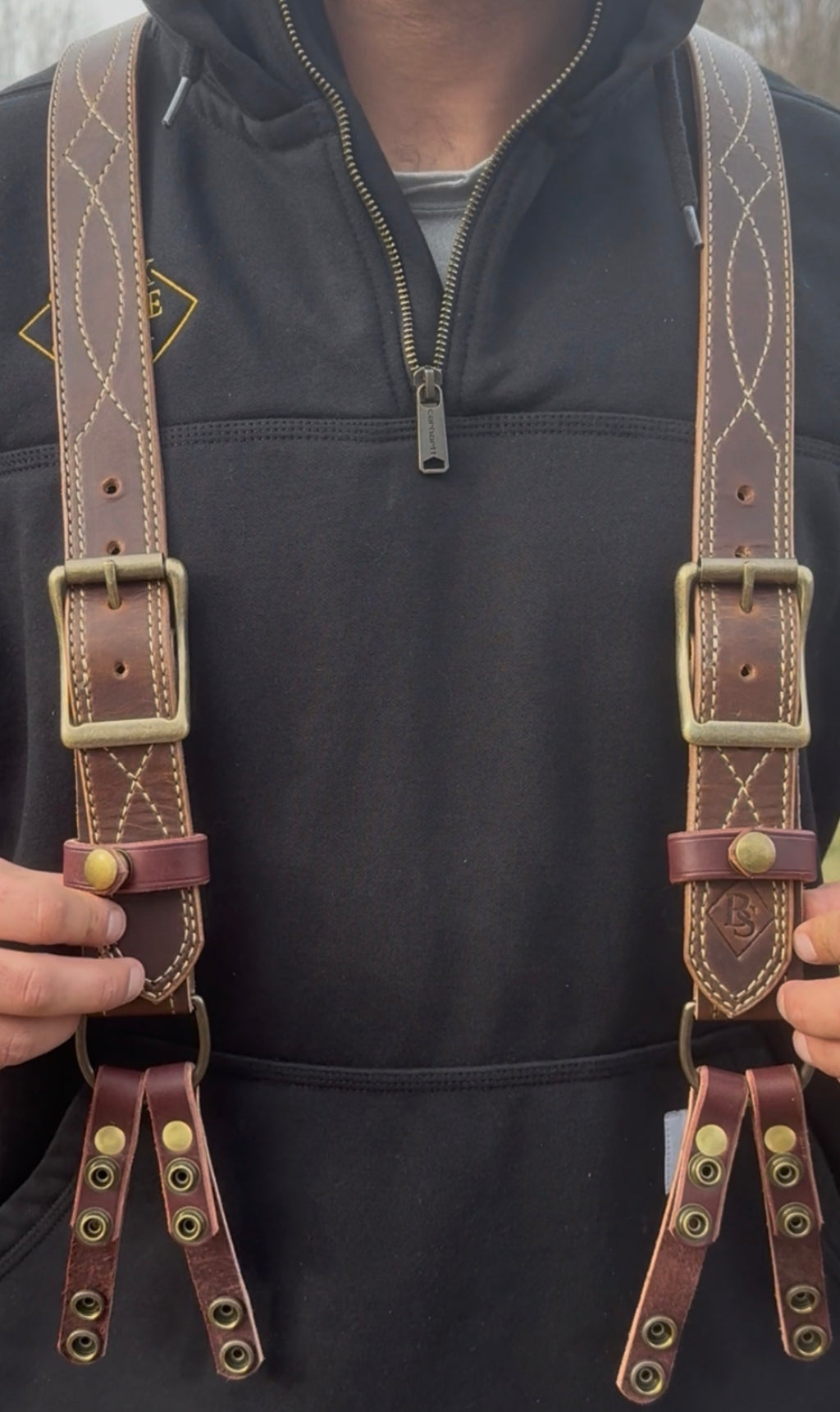 Brown Gunslinger suspenders with brass buckles on a plain background