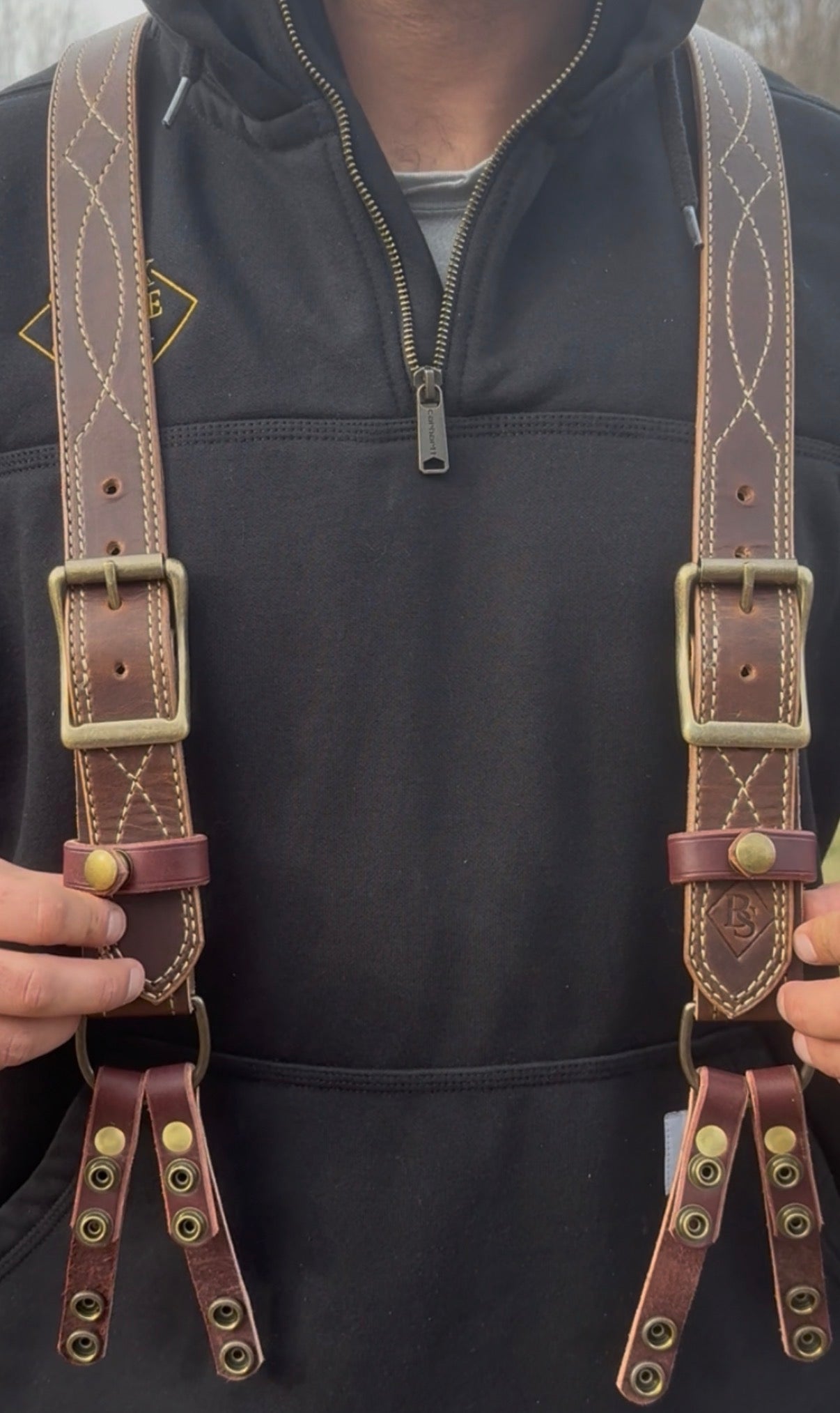 Brown Gunslinger suspenders with brass buckles on a plain background